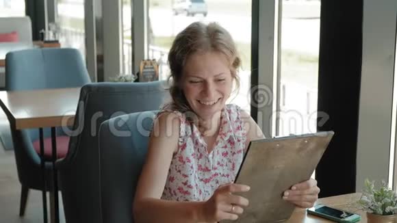 女人正在餐厅看菜单视频的预览图