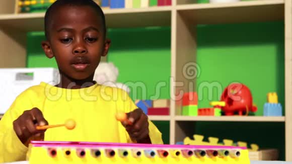 可爱的小男孩在教室里玩木琴视频的预览图