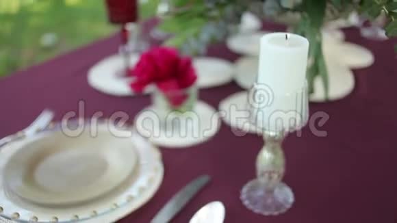 婚礼桌装饰在大自然点燃蜡烛特写视频的预览图