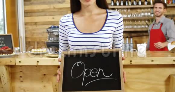 女子站在4k咖啡馆的开放式指示牌上视频的预览图