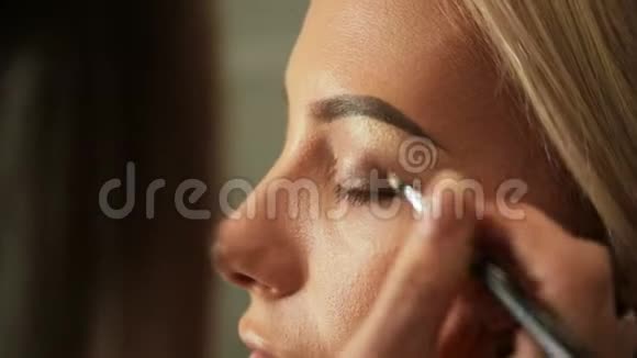 美容院化妆师用刷子画眉毛金发美女视频的预览图