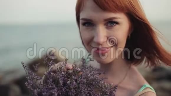 肖像慢动作美丽的女孩在大海的背景上带着美丽的微笑视频的预览图