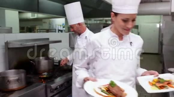 微笑厨师展示两道菜的镜头视频的预览图