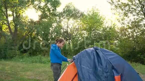 日落时分女人正在森林里搭一个旅游帐篷视频的预览图