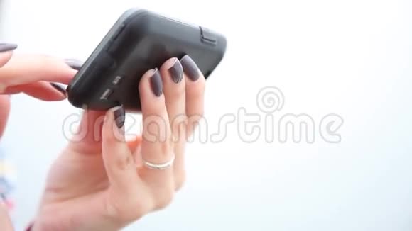女人用手机的手女孩在智能手机上发短信视频的预览图