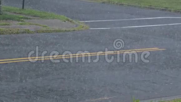 夏季雷雨时大雨落在柏油路上视频的预览图