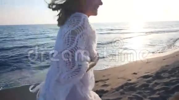 美丽的年轻女子在海滩上奔跑视频的预览图