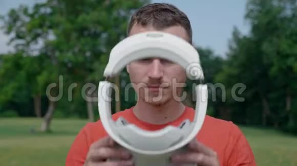 公园里一个男人把VR耳机戴在头上视频的预览图