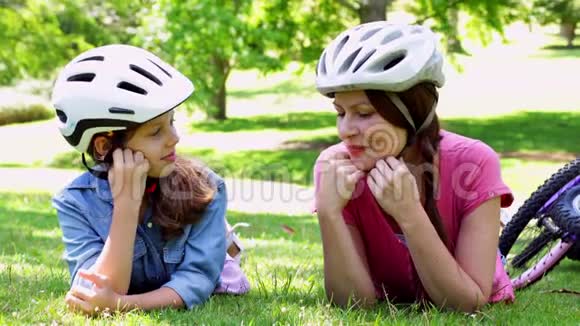 母亲和女儿在公园骑自行车休息视频的预览图