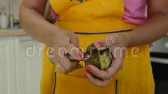 一个修了橙色指甲的女人剥土豆皮视频的预览图