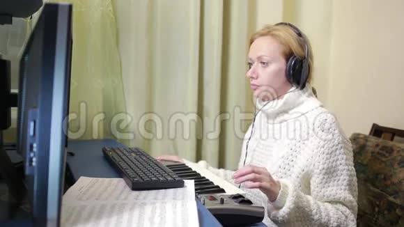 女人在电脑上写音乐数字钢琴MID键盘视频的预览图