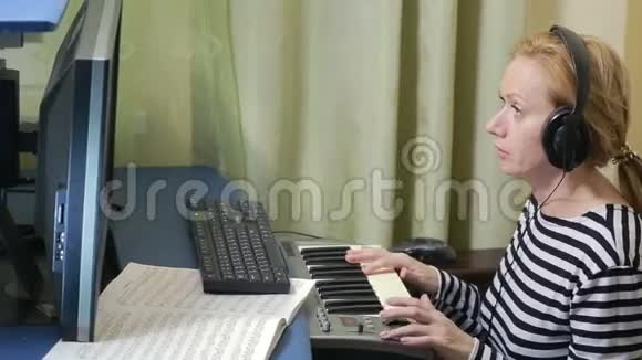 女人在电脑上写音乐数字钢琴MID键盘视频的预览图