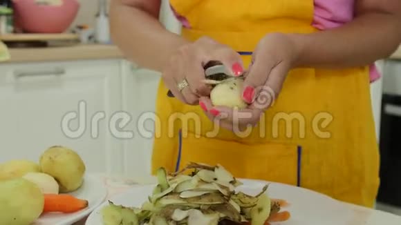 一个修了橙色指甲的女人剥土豆皮视频的预览图