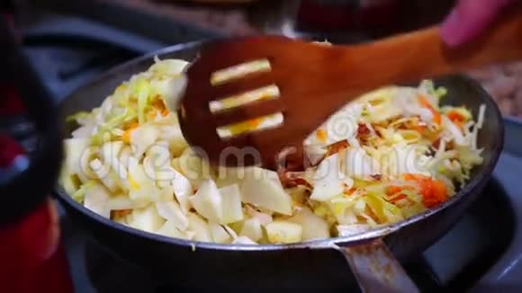 女人在锅里煮着炖白菜和胡萝卜视频的预览图