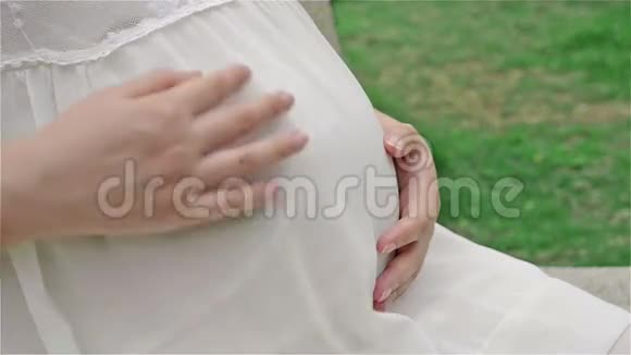 年轻孕妇抚摸着小宝宝的腹部视频的预览图