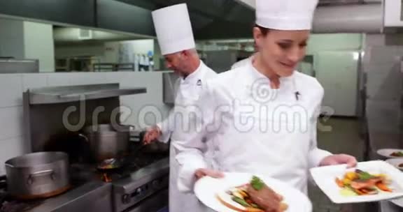 微笑厨师展示两道菜的镜头视频的预览图