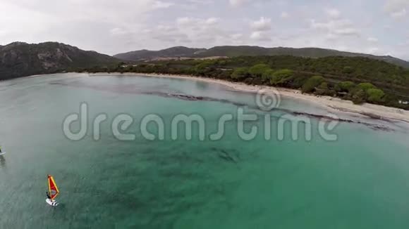 在法国科西嘉圣朱利亚海滩与冲浪者飞越海湾空中观景视频的预览图