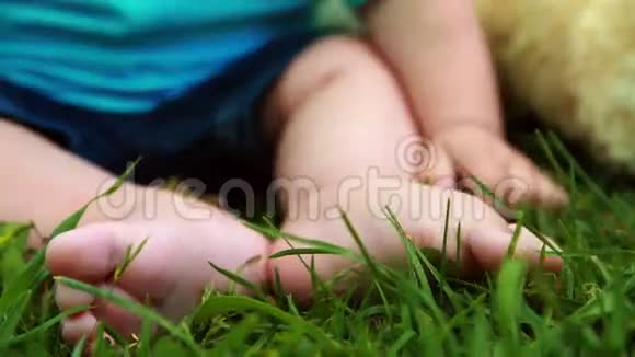可爱的小男孩和玩具熊坐在草地上视频的预览图