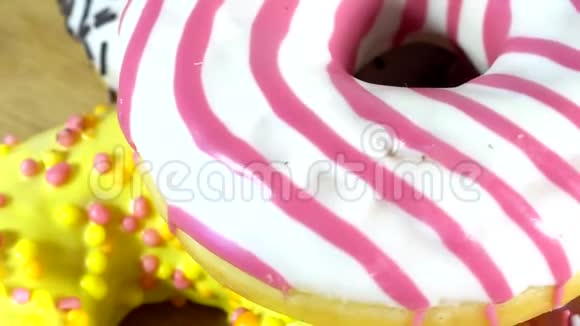 旋转甜甜圈与不同的填充在桌子上美味的甜面圈在盘子上旋转色彩鲜艳视频的预览图
