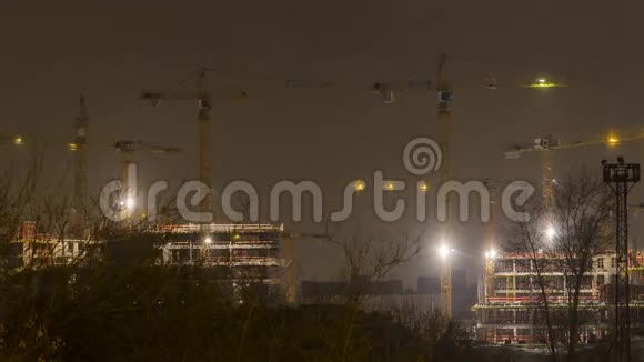 夜间工作的起重机和前A工业区房屋建筑的暴风雪视频的预览图