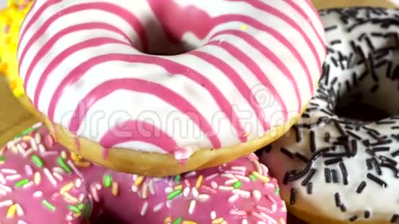 旋转甜甜圈与不同的填充在桌子上美味的甜面圈在盘子上旋转色彩鲜艳视频的预览图
