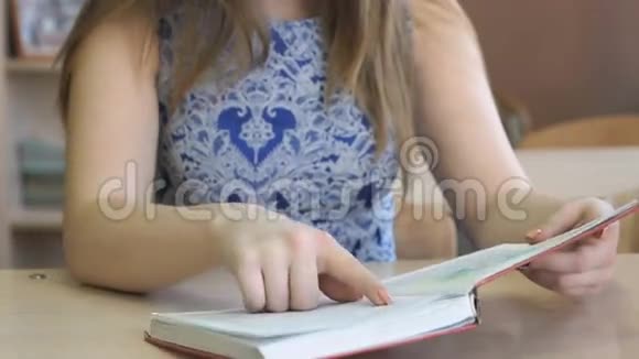 坐在书桌旁的学生在室内读课本视频的预览图