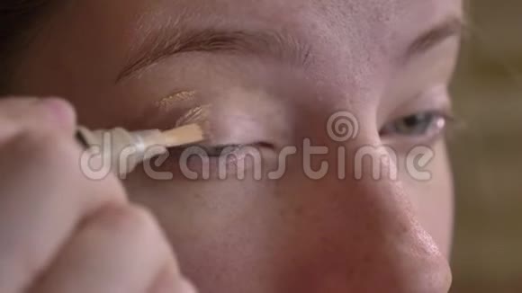 年轻的白种人化妆师用刷子涂抹遮瑕膏的特写肖像视频的预览图