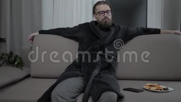 英俊的胡子男人在沙发上放松视频的预览图