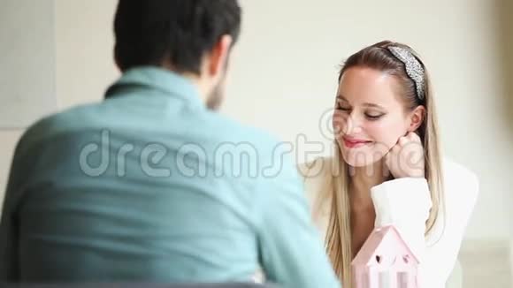 一位美丽的金发女人在餐馆里和男人说话视频的预览图
