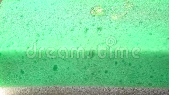 在绿色海绵和手上浸泡的液体肥皂视频的预览图