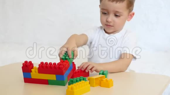 快乐的孩子坐在桌子旁用彩色积木玩视频的预览图