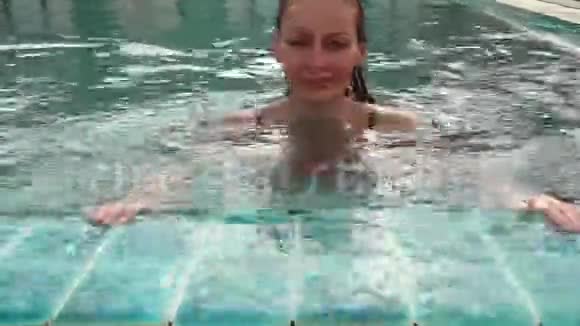 年轻女子在游泳池里放松和慢慢游泳视频的预览图