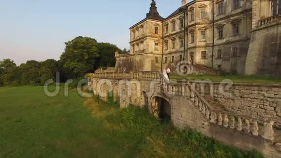 鸟瞰城堡背景上美丽的婚礼情侣4k视频的预览图