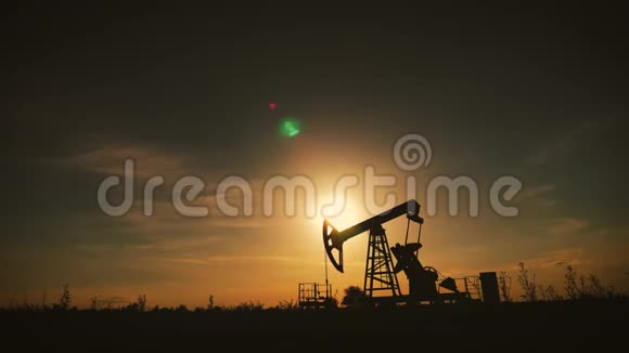 日落时油田工作油泵剪影工业设备视频的预览图
