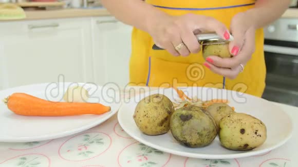 一个修了橙色指甲的女人剥土豆皮视频的预览图