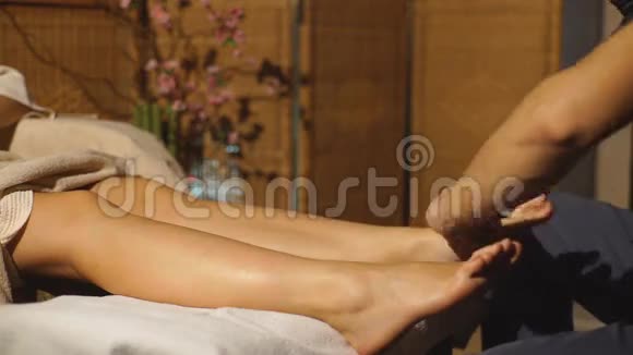 漂亮的金发女孩在做足部按摩治疗按摩视频的预览图