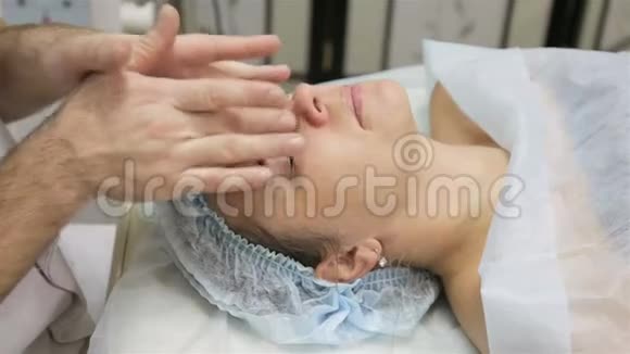 女人接受面部按摩美容院的治疗视频的预览图