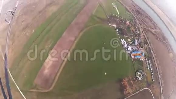 跳伞员跳伞在绿色的田野道路上方的天空中专业人员景观视频的预览图