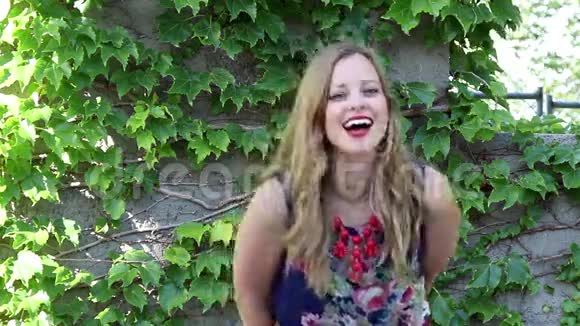 年轻的女人带着常春藤的背景笑视频的预览图