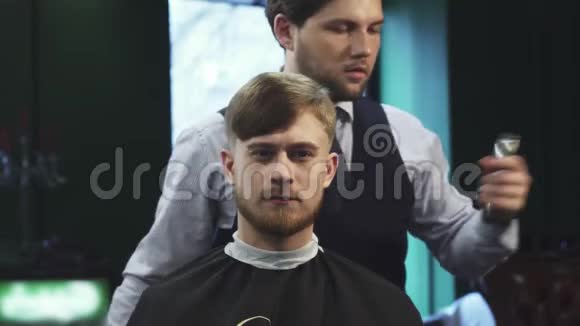 英俊的年轻人在理发店理发视频的预览图