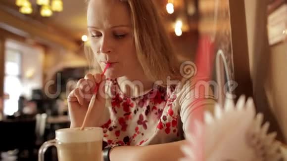 咖啡馆里喝咖啡拿铁的女孩肖像视频的预览图