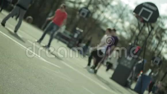 青少年在城市公园打篮球伤口视频的预览图