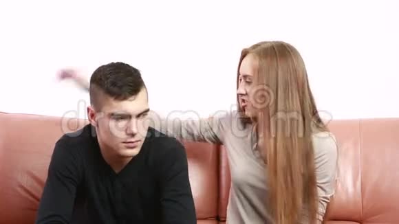 一对漂亮的年轻夫妇坐在沙发上争论不开心视频的预览图
