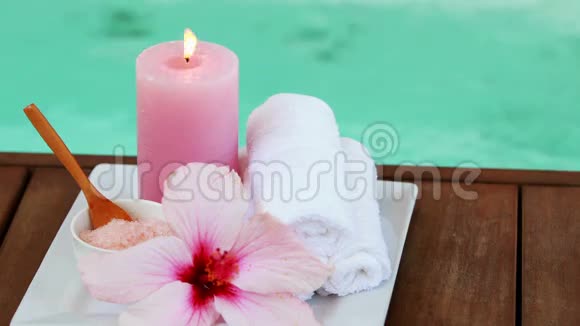 泳池旁的毛巾蜡烛和粉红色的花视频的预览图