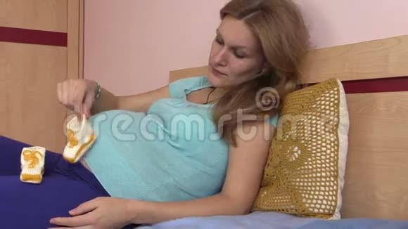孕妇围着肚子玩漂亮的婴儿鞋视频的预览图