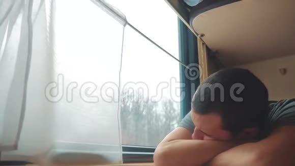 人在火车上睡觉疲惫的长途铁路旅行火车铁路旅行慢动作视频窗外美丽视频的预览图