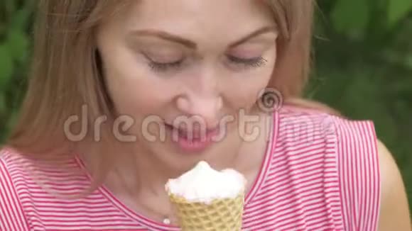 女人舔冰淇淋女孩在舔一个美味的奶油冰淇淋有草莓味的冰淇淋甜筒视频的预览图