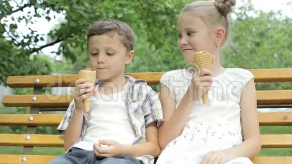 两个快乐的孩子在公园里吃冰淇淋视频的预览图