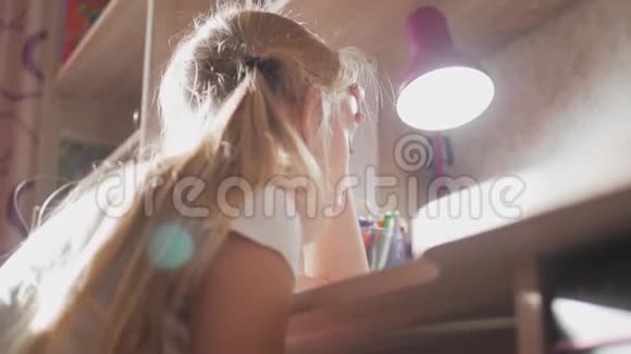 小女孩在灯光下在桌子上做作业小公主的创作爱好生活方式视频的预览图