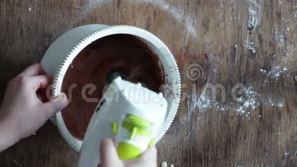 在白色塑料碗中用电动搅拌器搅拌巧克力饼干面团视频的预览图